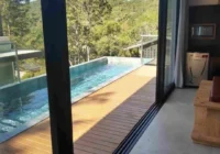 Sala com vista para piscina e natureza — casa