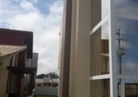 Lateral da casa com ampla fachada de vidro
