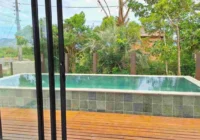Piscina com deck de madeira vista pela janela — casa