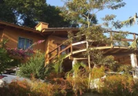 Fachada de casa rústica cercada por verde