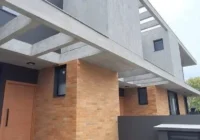 Fachada moderna com pérgola e revestimento de tijolinhos — casa