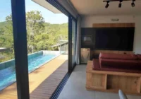 Sala integrada com deck e piscina com vista — casa
