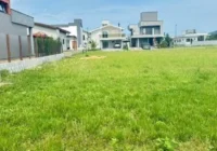 Terreno gramado no condomínio com casas ao fundo — Condomínio Rosa Internacional