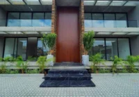 Fachada da residência com imensa porta de madeira — Residencial Alexandrina