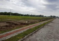 Terreno plano em loteamento com rua pavimentada