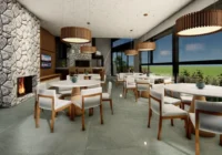 Espaço gourmet interno com lareira e mesas — Condomínio Pôr do Sol